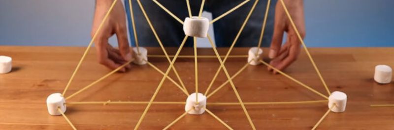 marshmallow and spaghetti noodle tower on a table 