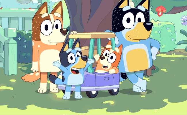 The Heeler Family from the Kids' tv show, Bluey. Mum, Bingo, Bluey and Dad standing outside with toy car